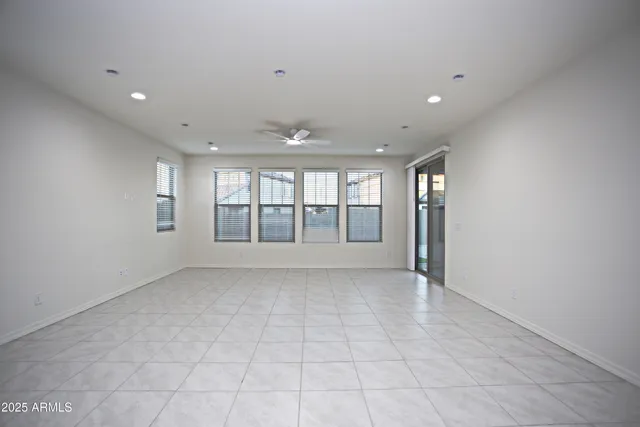 an empty room with a ceiling fan and window