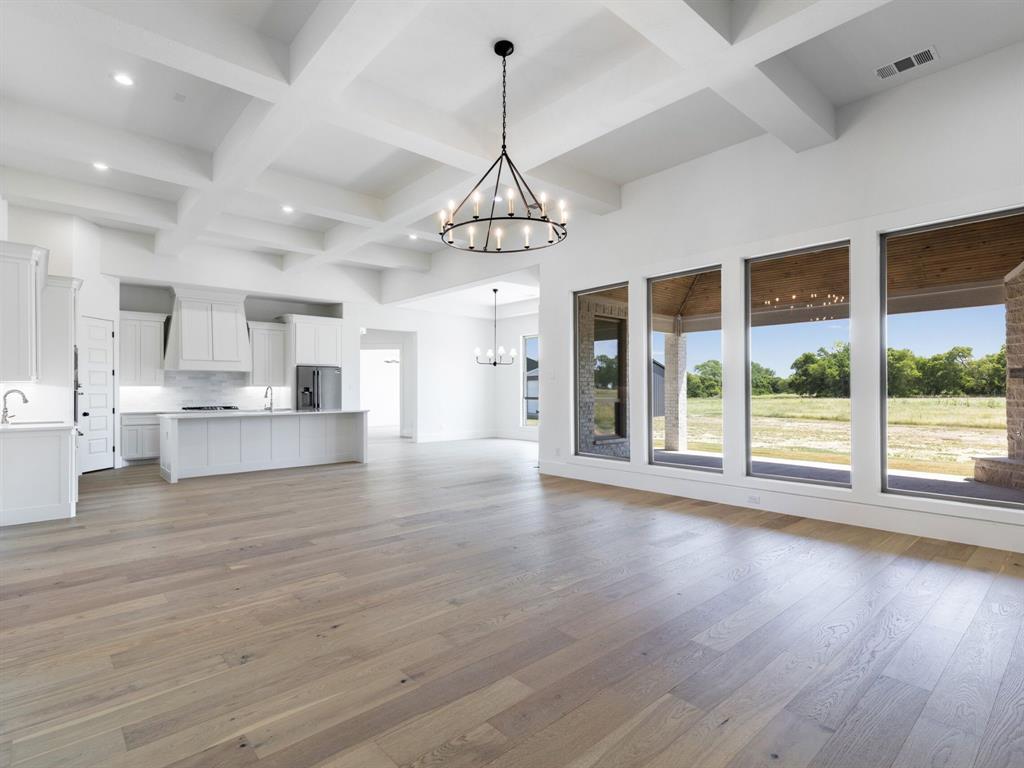 7 William Brewer Road Collinsville, TX 76233 - Photo 16 of 16 a view of an empty room with wooden floor and a kitchen