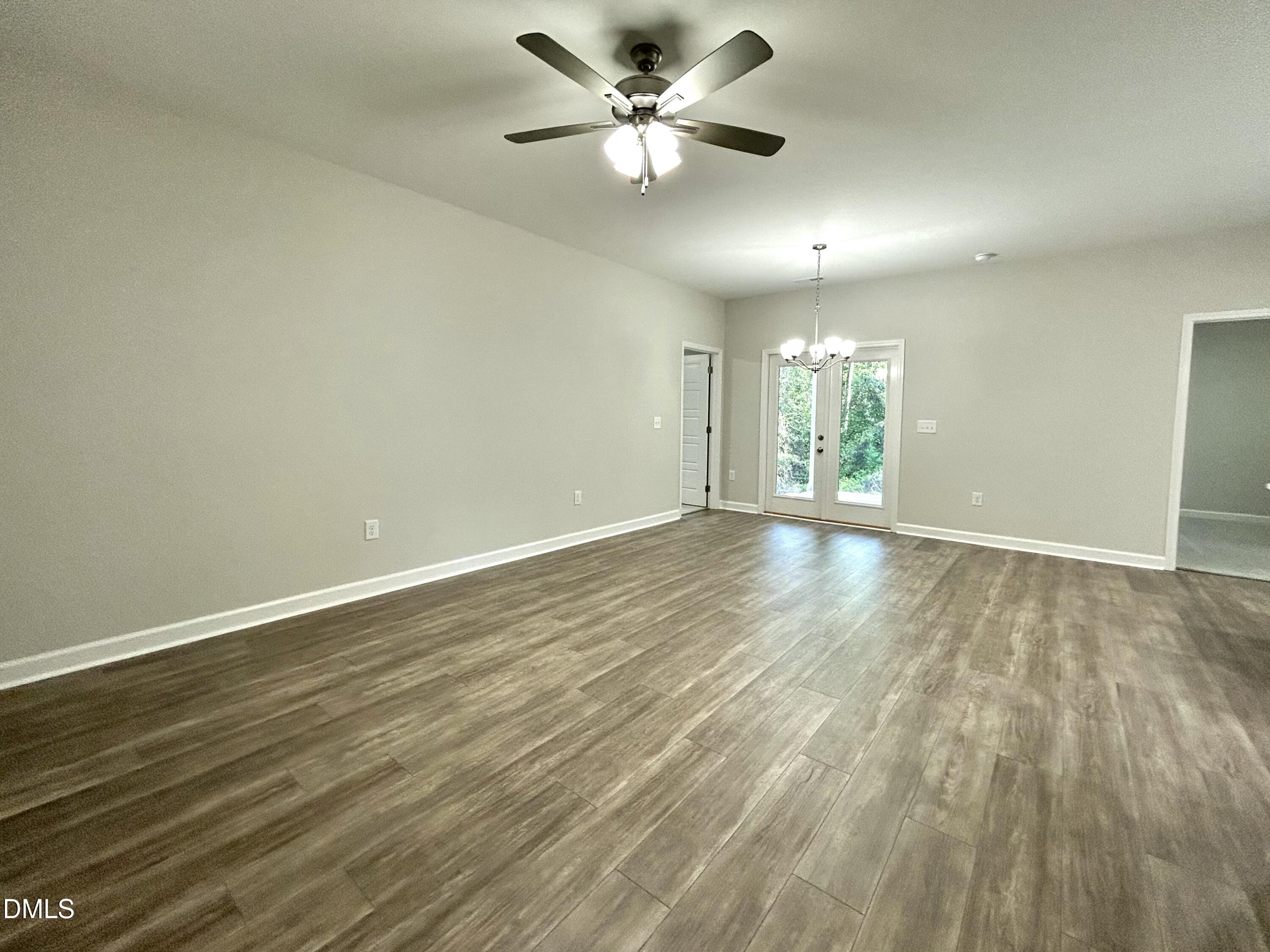 1702 Cardinal Drive Deep Run, NC 28525 - Photo 6 of 21 an empty room with wooden floor and a ceiling fan