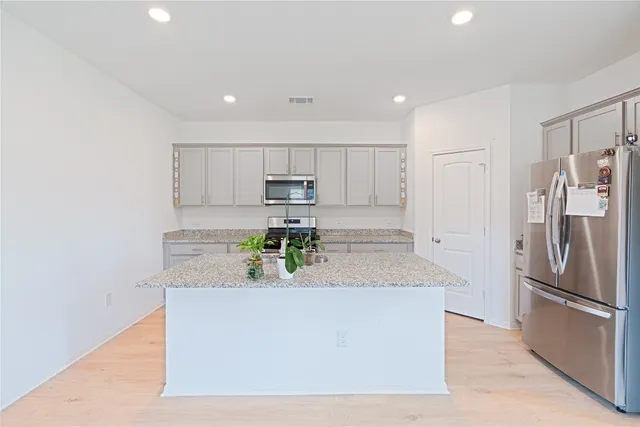 a kitchen with stainless steel appliances granite countertop a refrigerator and a stove