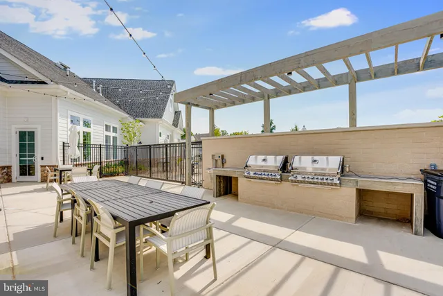 a view of a kitchen with kitchen island a sink wooden floor and a large window