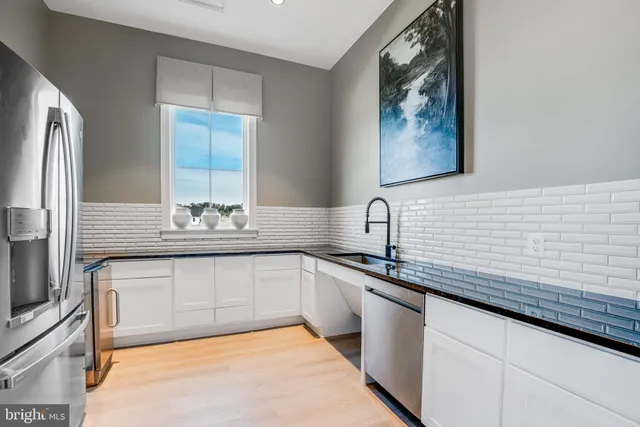 a view of a house with a yard and a large tree