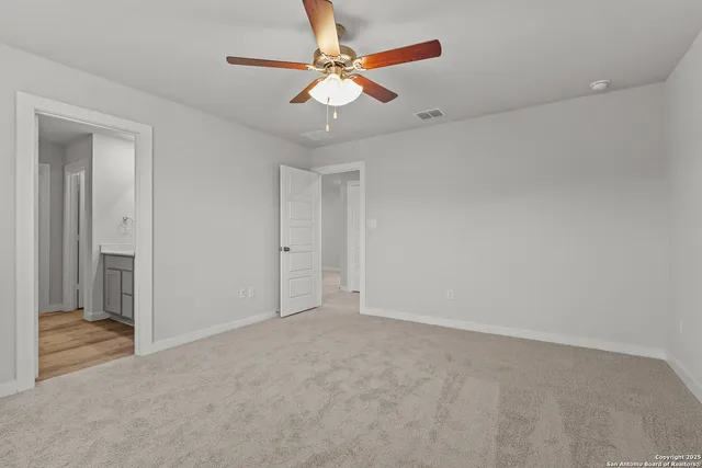 an empty room with a ceiling fan and a window