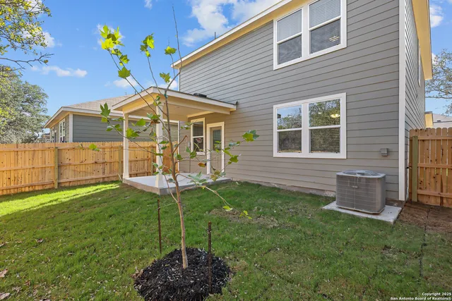 a view of a backyard with table and chairs with wooden fence