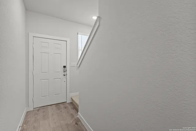 a view of hallway with closet and wooden floor