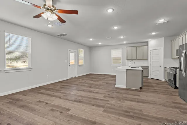 a view of kitchen with kitchen island wooden floor center island and appliances