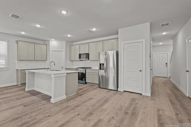 a kitchen with white cabinets and white appliances