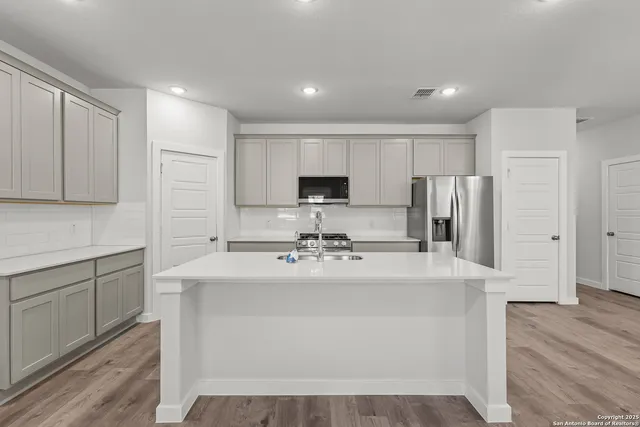 a kitchen with stainless steel appliances a refrigerator sink and microwave