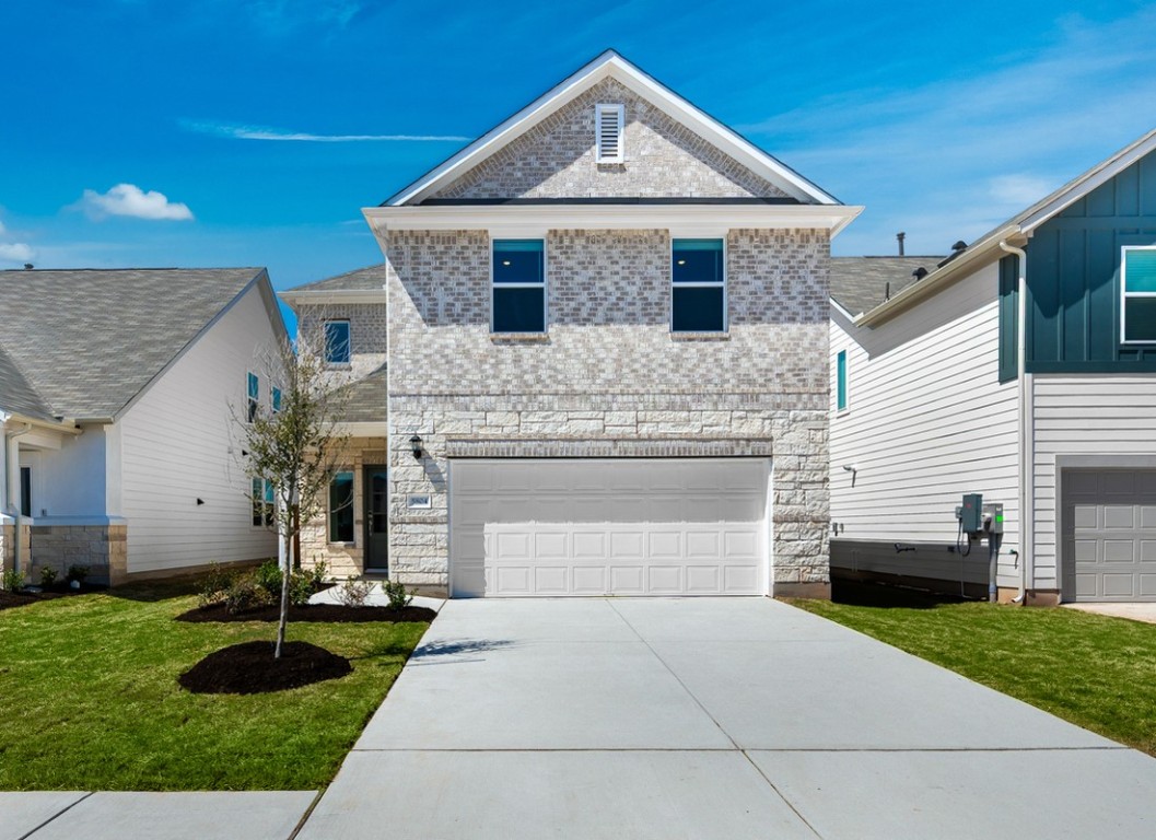 a front view of a house with a yard and garage