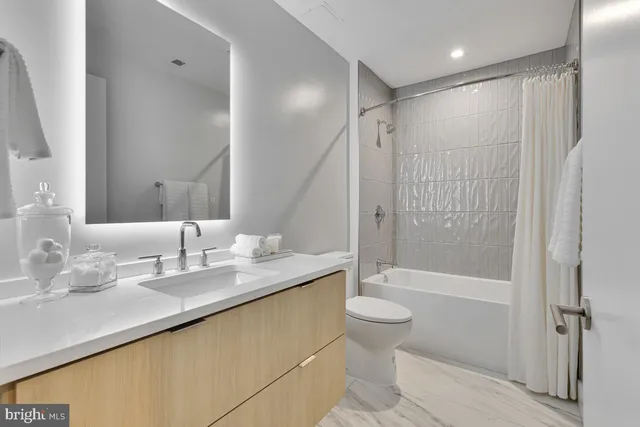 a bathroom with a granite countertop sink a toilet and shower