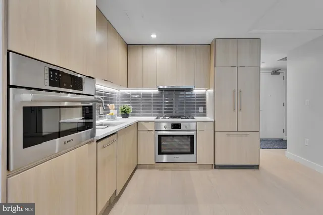 a kitchen with stainless steel appliances granite countertop a stove and a microwave
