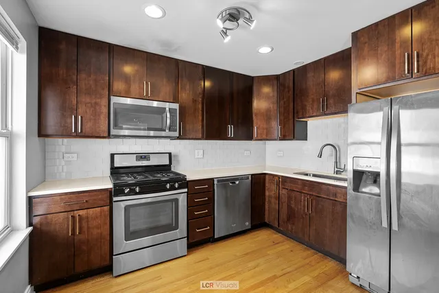 a kitchen with stainless steel appliances granite countertop wooden cabinets a stove top oven a sink and dishwasher