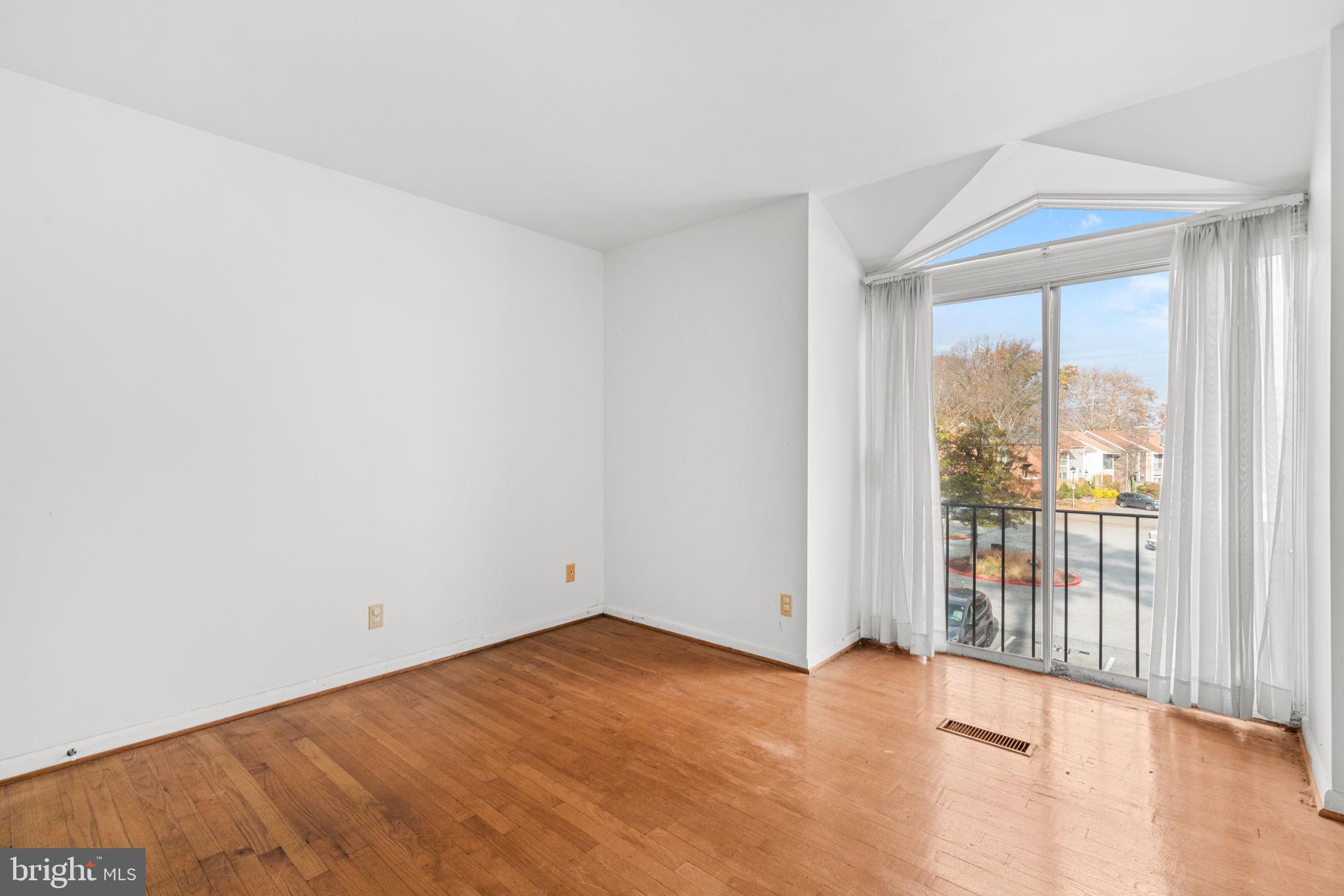 10390 May Wind Court Columbia, MD 21044 - Photo 16 of 29 a view of an empty room with wooden floor and a window