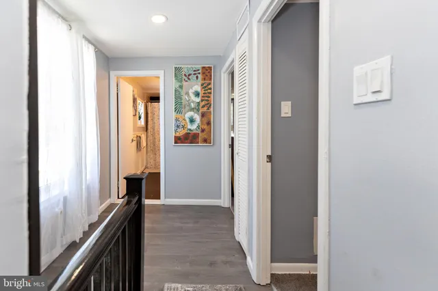 a view of a hallway with wooden floor and staircase