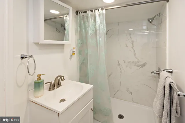 a bathroom with a sink mirror and shower
