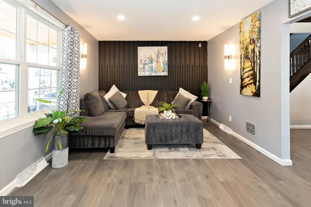 a living room with furniture and potted plants