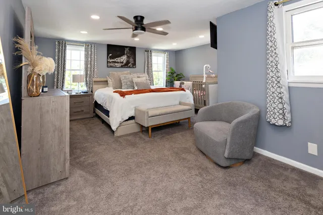 a spacious bedroom with a bed couch and window