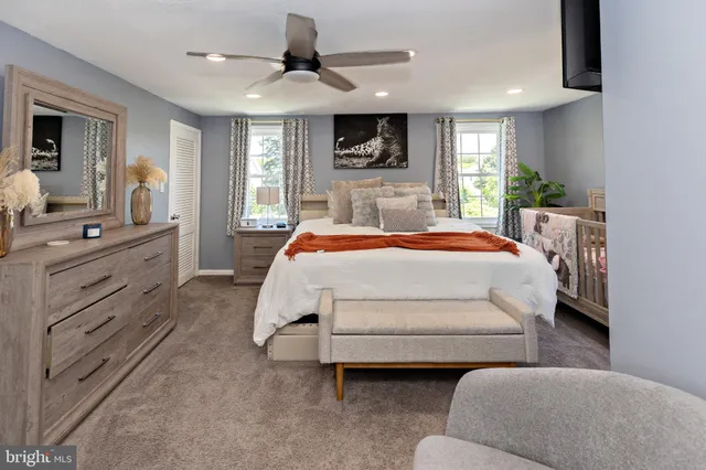 a bedroom with a large bed a flat tv screen and a dresser