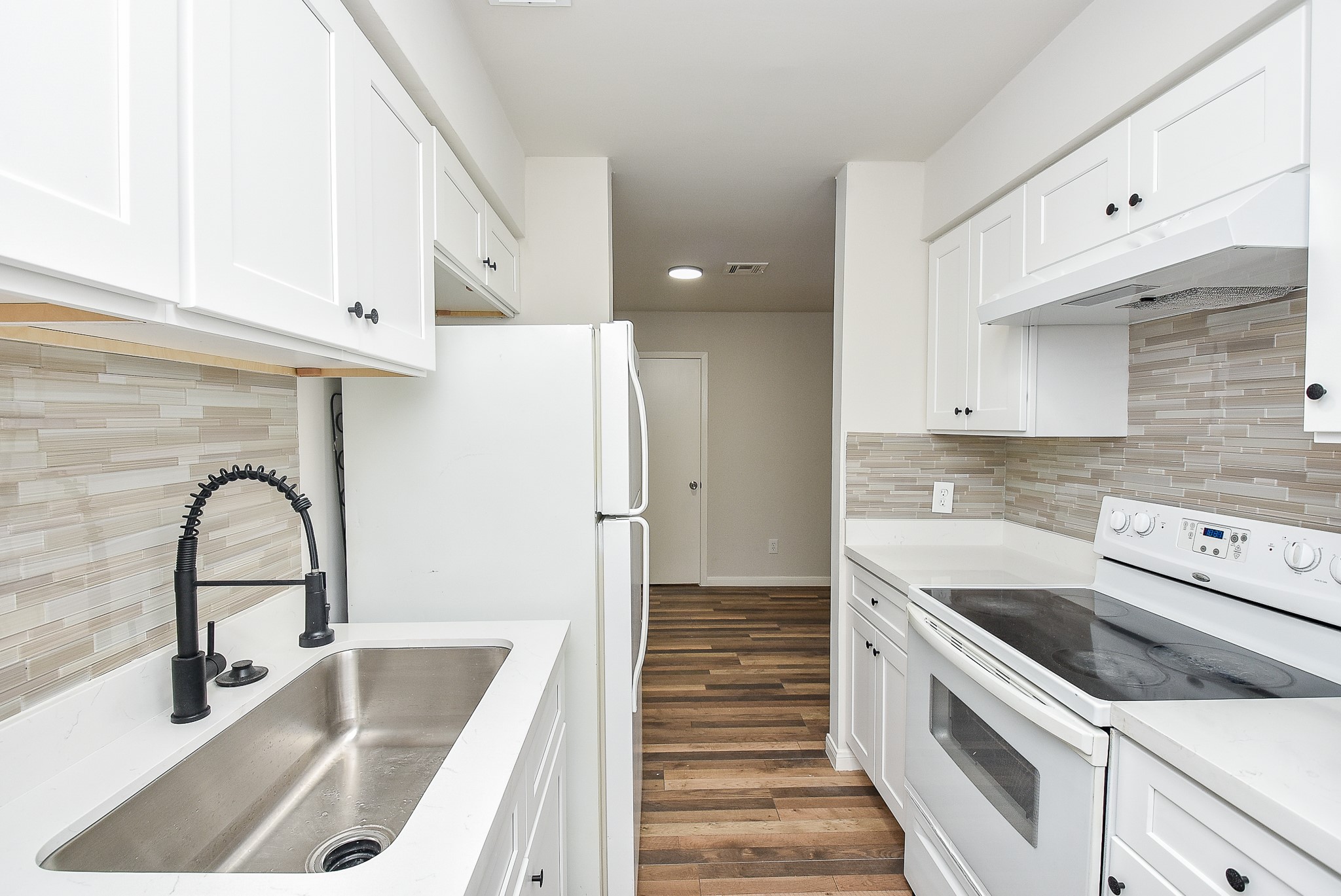 3644 Ocee Street Houston, TX 77063 - Photo 15 of 32 a kitchen with a sink a refrigerator and cabinets