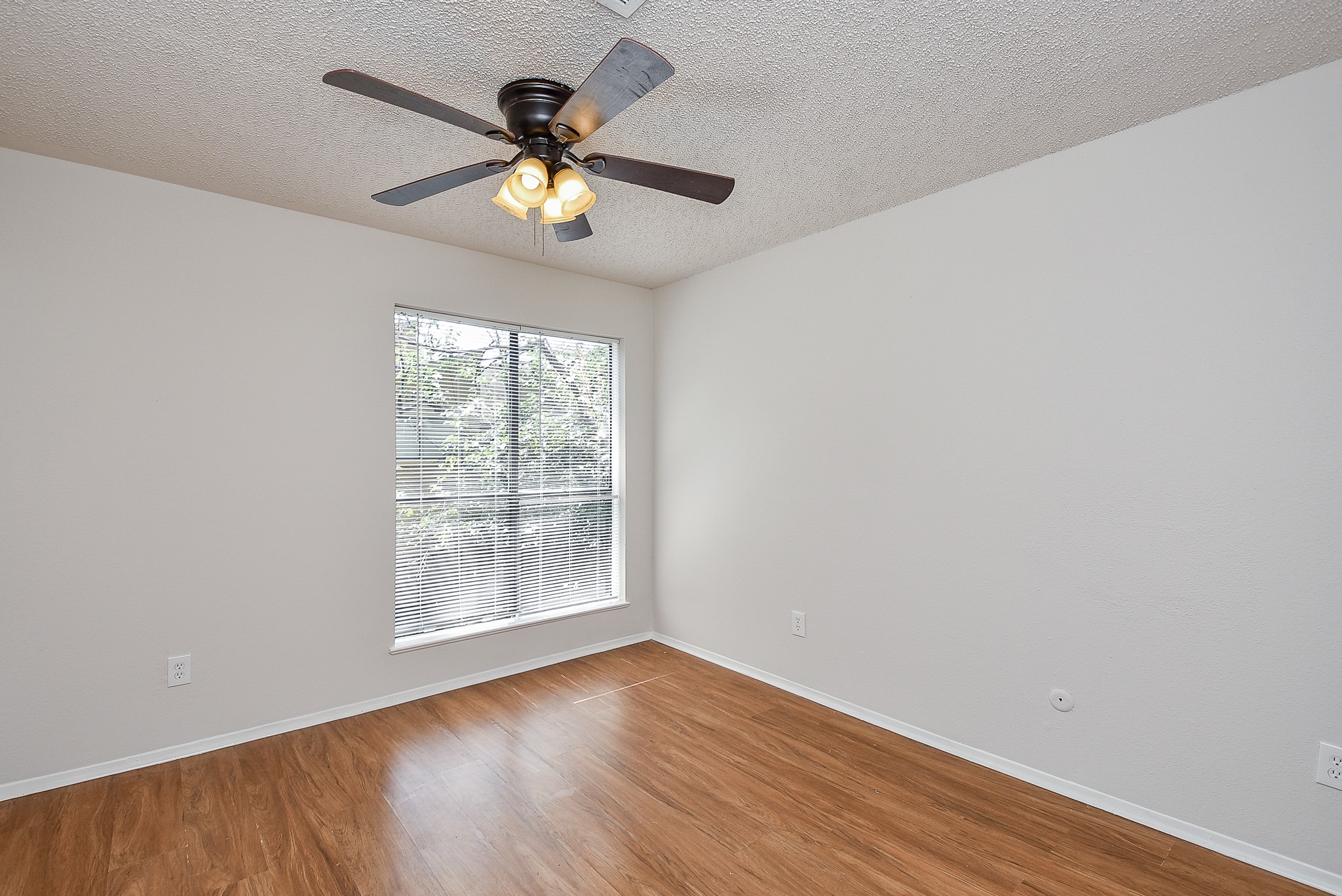 3644 Ocee Street Houston, TX 77063 - Photo 30 of 32 an empty room with wooden floor chandelier fan and windows
