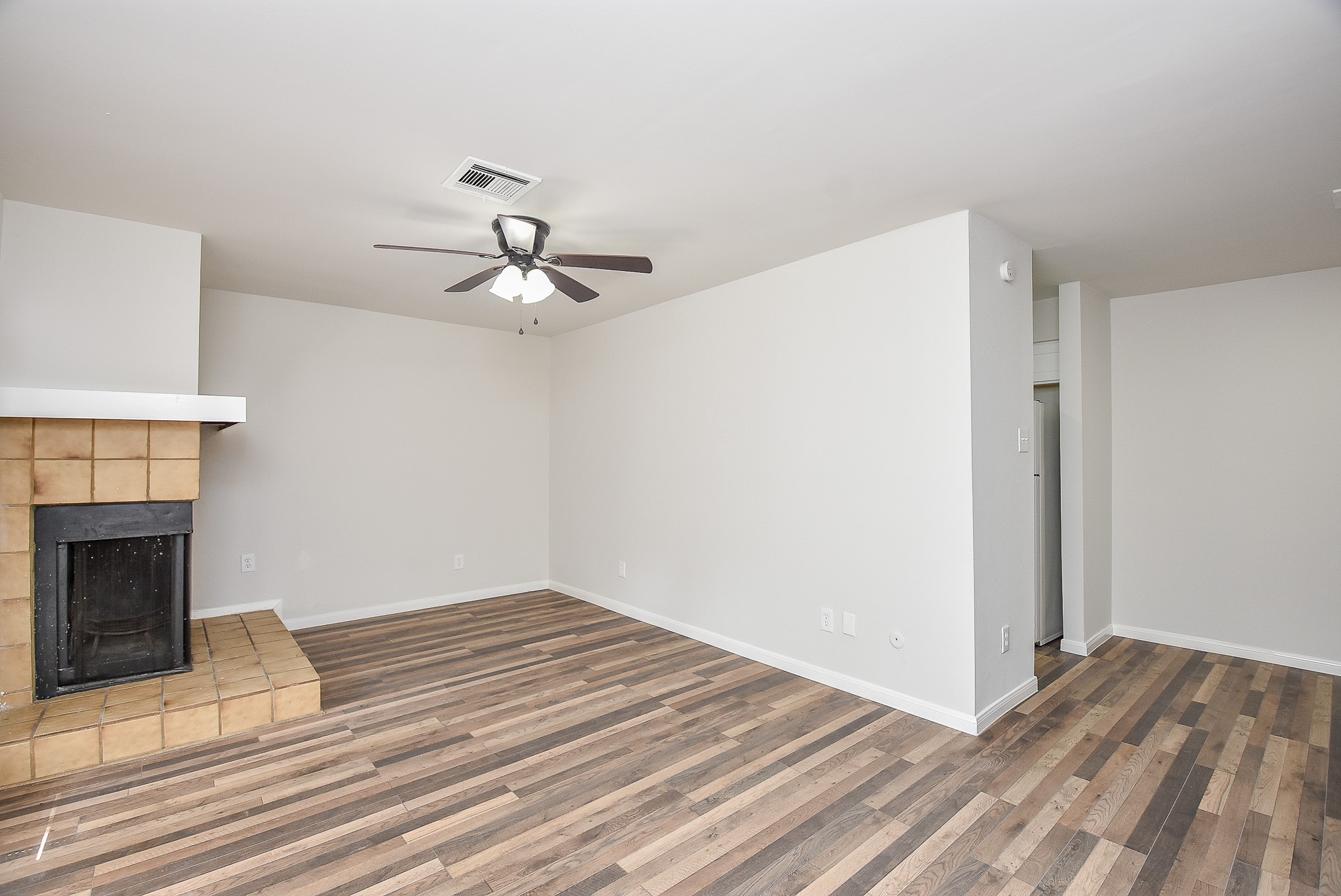 3644 Ocee Street Houston, TX 77063 - Photo 7 of 32 a view of a livingroom with a fireplace a chandelier fan and wooden floor