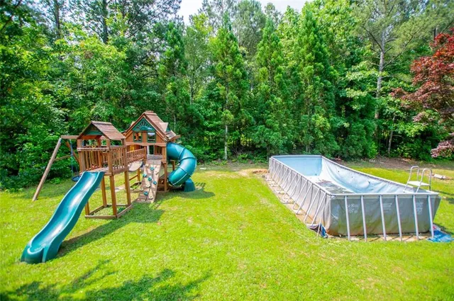 a kitchen with stainless steel appliances granite countertop wooden cabinets a sink dishwasher and a stove with wooden floor