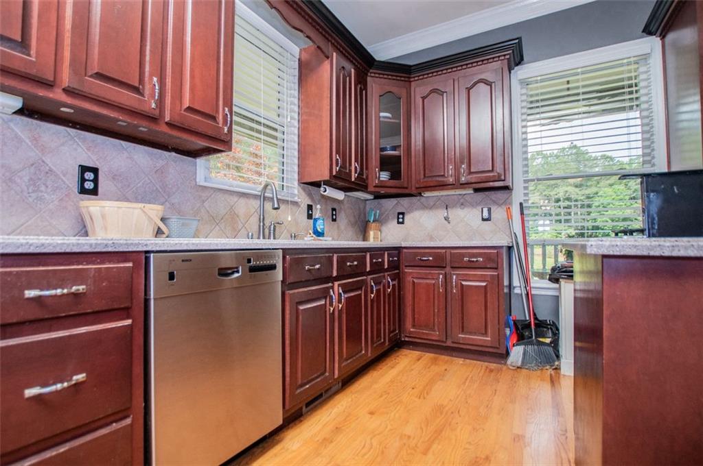 6919 Mt Zion Road Waco, GA 30182 - Photo 24 of 79 a kitchen with stainless steel appliances granite countertop wooden cabinets a sink and dishwasher a stove with wooden floor