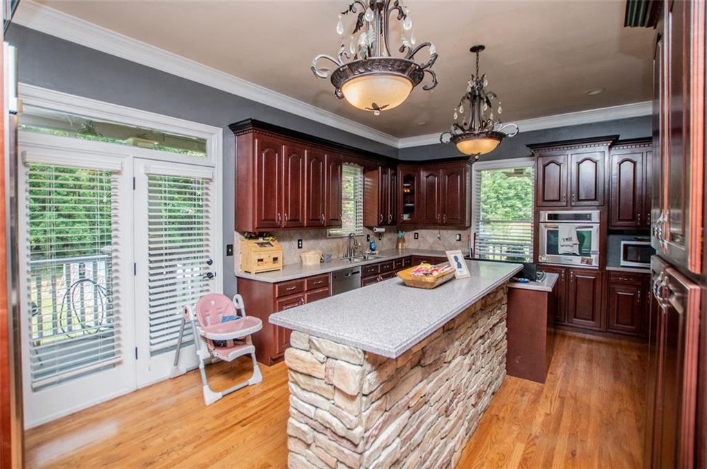 6919 Mt Zion Road Waco, GA 30182 - Photo 28 of 79 a kitchen with a refrigerator a stove top oven a sink dishwasher and wooden cabinets with wooden floor
