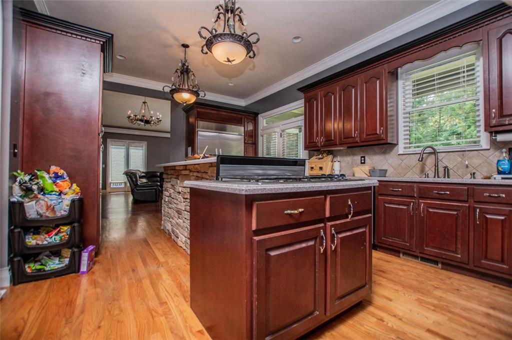 6919 Mt Zion Road Waco, GA 30182 - Photo 31 of 79 a kitchen with stainless steel appliances granite countertop wooden cabinets a sink dishwasher and a stove with wooden floor