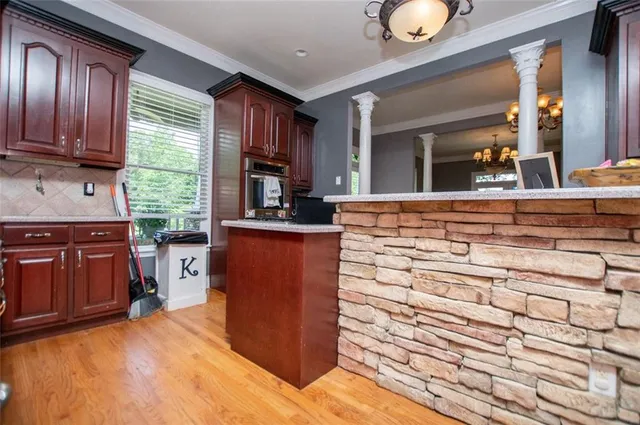 a spacious bedroom with a bed and a flat tv screen on the dresser