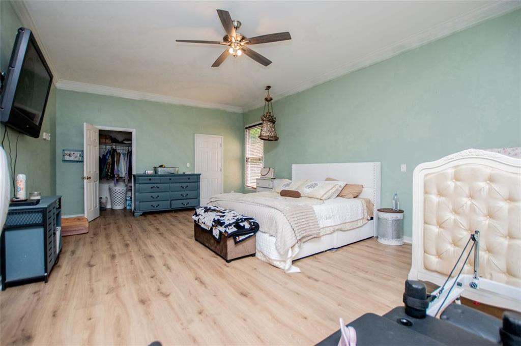 6919 Mt Zion Road Waco, GA 30182 - Photo 49 of 79 a spacious bedroom with a bed and a flat tv screen on the dresser