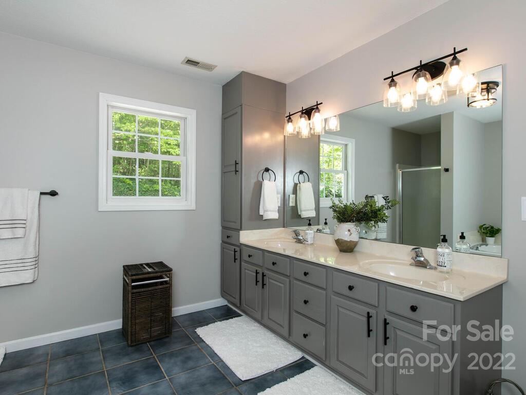 15 Devonshire Drive Candler, NC 28715 - Photo 26 of 43 a bathroom with a double vanity sink a mirror a and a window