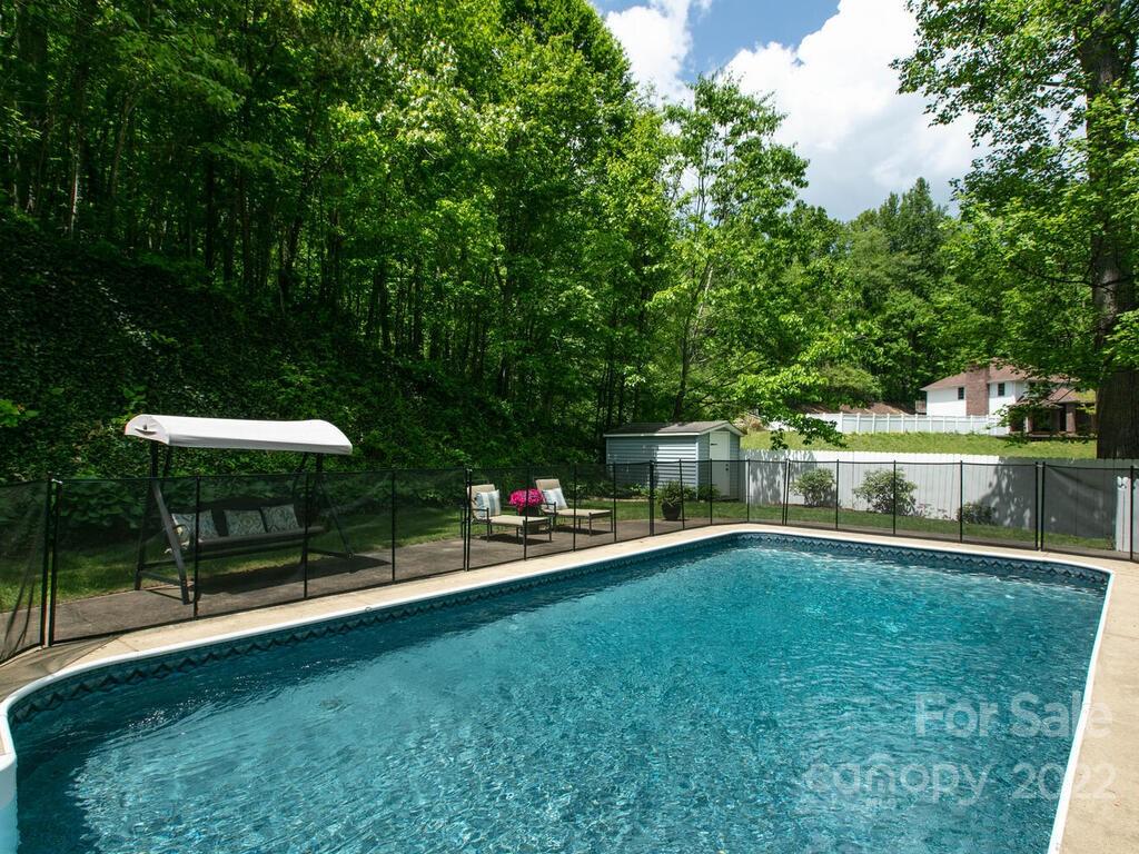 15 Devonshire Drive Candler, NC 28715 - Photo 36 of 43 a view of a swimming pool with a table and chairs under an umbrella
