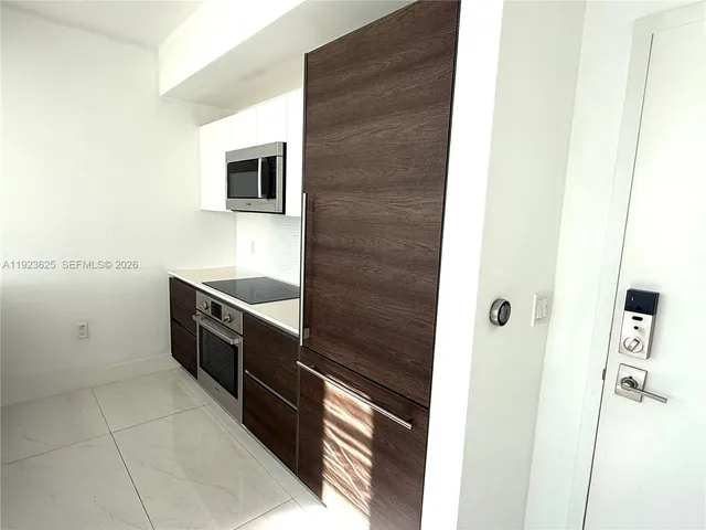 a kitchen with stainless steel appliances a stove a microwave and a sink