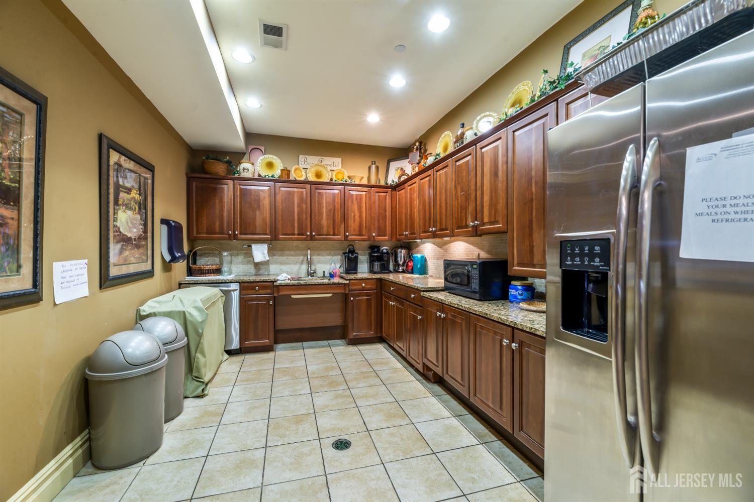 540 Cranbury Road, Unit 104 East Brunswick, NJ 08816 - Photo 26 of 43 a kitchen with stainless steel appliances granite countertop a refrigerator a sink and wooden cabinets