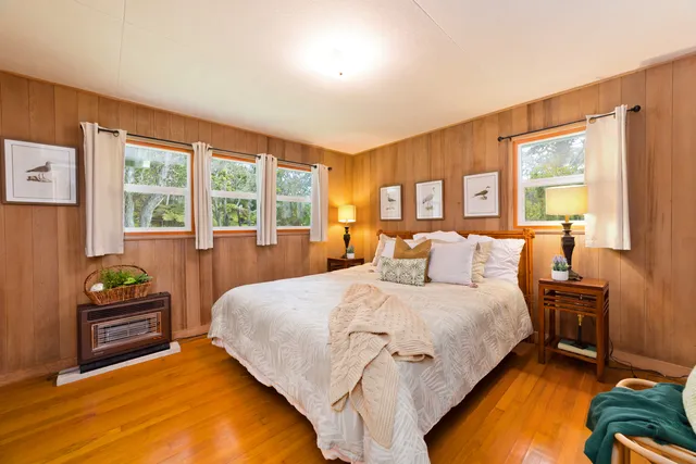 a bedroom with a bed and large windows