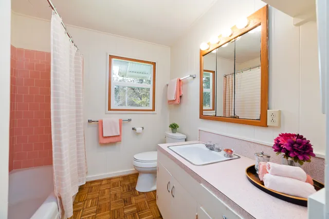 a bathroom with a sink mirror vanity and toilet