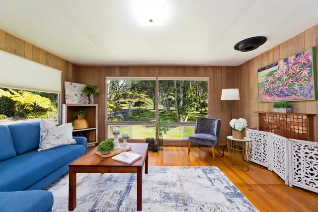 a living room with furniture floor to ceiling window and wooden floor