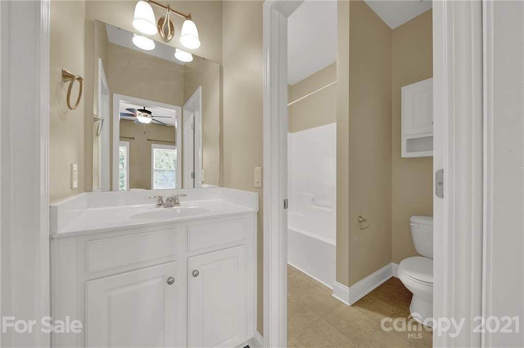 392 Windell Drive Fort Mill, SC 29708 - Photo 25 of 40 a en suite bathroom with a granite countertop sink a toilet and a mirror