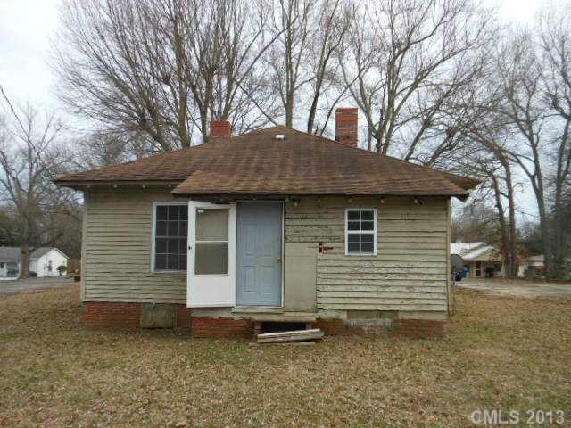 914 Ki Pope Road Belmont, NC 28012 - Photo 8 of 8 a backyard of a house with large trees and brick wall