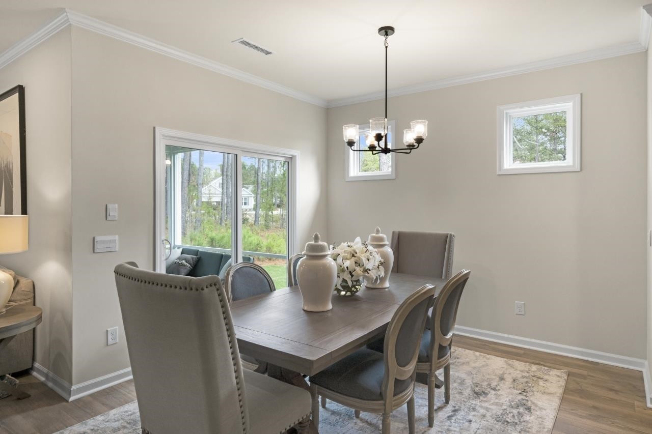 350 Madden Rose Loop Garner, NC 27529 - Photo 14 of 27 a dining room with furniture a chandelier and wooden floor