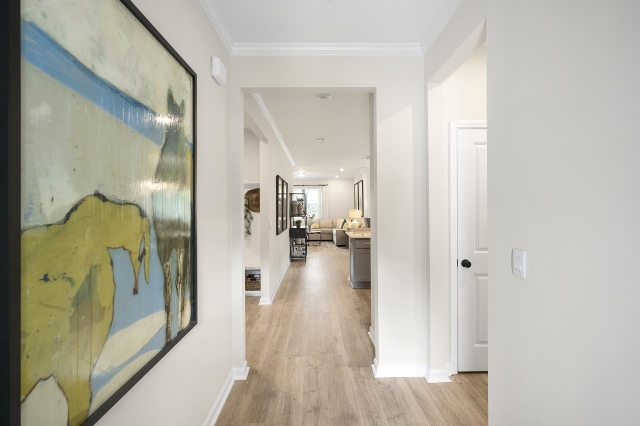 350 Madden Rose Loop Garner, NC 27529 - Photo 8 of 27 a view of a hallway with wooden floor and a living room
