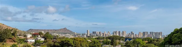 a view of a house with a garden and a sitting area