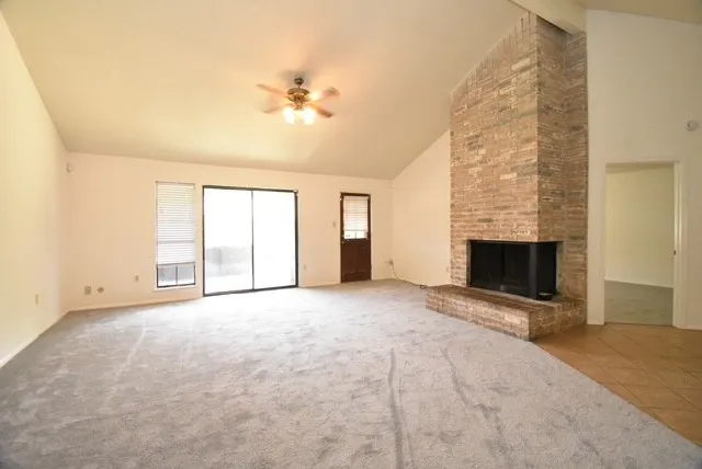 an empty room with windows and fireplace