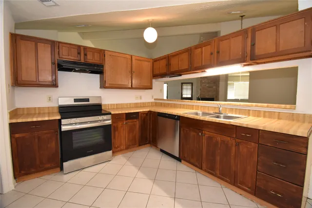 a kitchen with stainless steel appliances a stove sink and cabinets