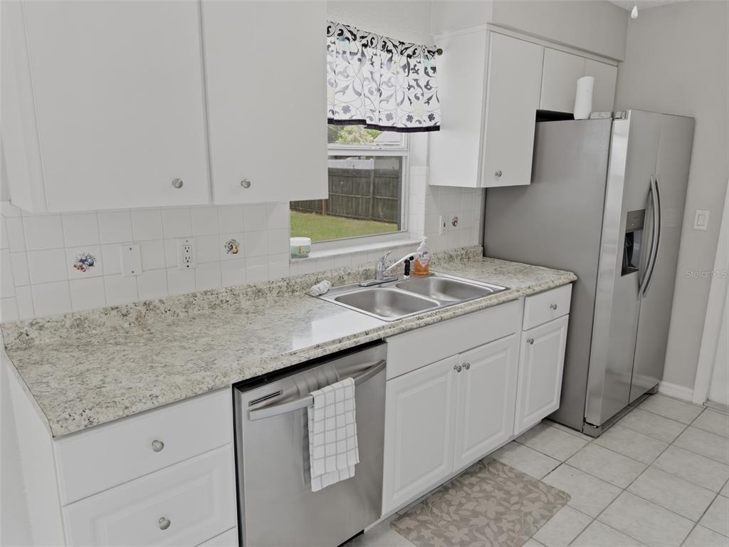 2202 Godfrey Avenue Spring Hill, FL 34609 - Photo 13 of 36 a kitchen with stainless steel appliances granite countertop a sink and a refrigerator