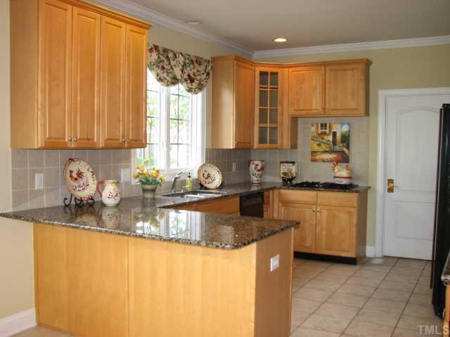 9012 Winged Thistle Court Raleigh, NC 27617 - Photo 5 of 12 The kitchen and breakfast room are open to the family room area. This warm and inviting room has a gas cook top and microwave. A first floor laundry room adjoins the back section of the kitchen.