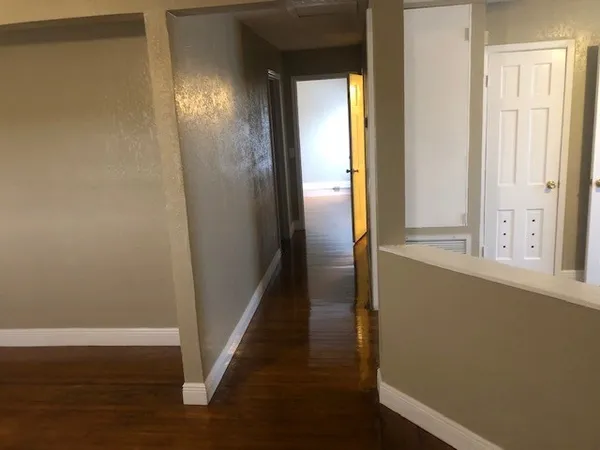 a view of a hallway with wooden floor