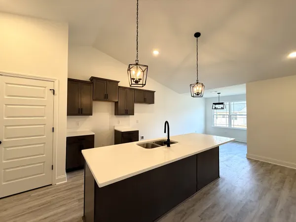 a kitchen with a sink a counter space and a refrigerator
