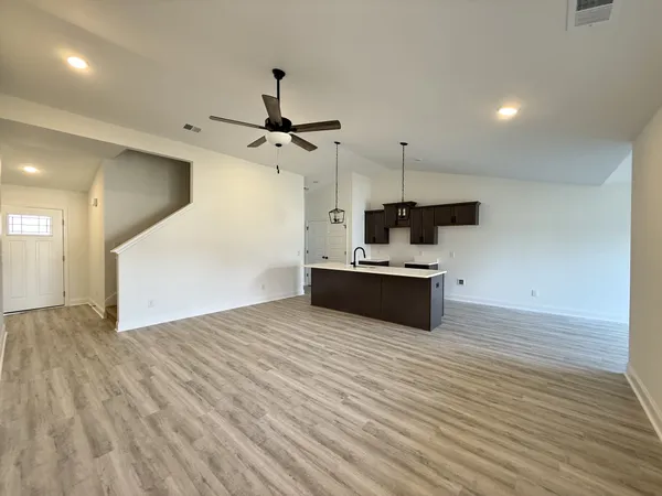 a large white kitchen with a sink dishwasher a kitchen with a stove and cabinets